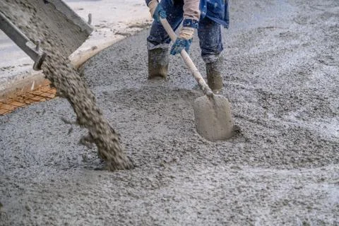 The process of pouring concrete on a prepared base made of sand Stock Photos