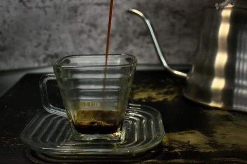 The process of pouring espresso produced mocha pot into a square-shaped coffe Stock Photos