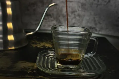 The process of pouring espresso produced mocha pot into a square-shaped coffe Stock Photos