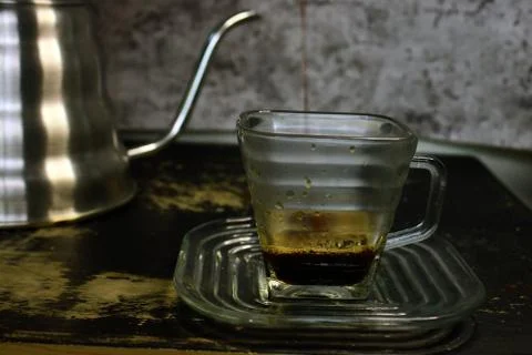 The process of pouring espresso produced mocha pot into a square-shaped coffe Stock Photos