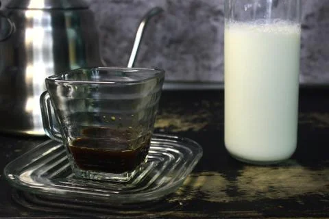 The process of pouring espresso produced mocha pot into a square-shaped coffe Foto stock