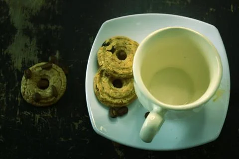 The process of pouring espresso on a white ceramic mug with some diet biscuit Foto stock