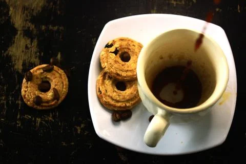 The process of pouring espresso on a white ceramic mug with some diet biscuit Stock Photos
