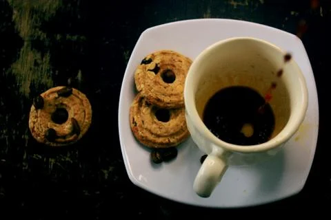 The process of pouring espresso on a white ceramic mug with some diet biscuit Stock Photos