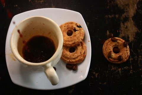 The process of pouring espresso on a white ceramic mug with some diet biscuit Stock Photos