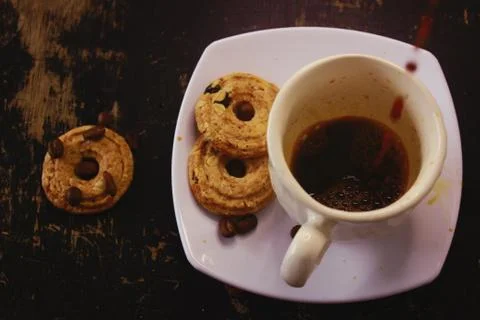 The process of pouring espresso on a white ceramic mug with some diet biscuit Stock Photos