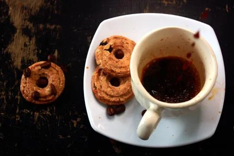 The process of pouring espresso on a white ceramic mug with some diet biscuit Stock Photos