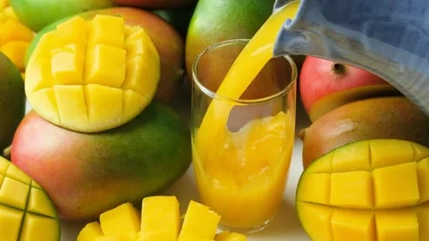 Process of pouring fresh mango juice into a glass slow motion Stock Footage 327799664
