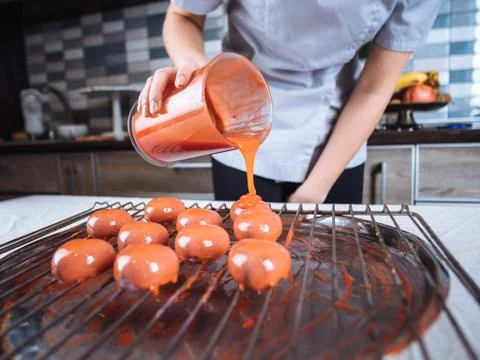 The process of pouring glaze on the cake  Stock Photos