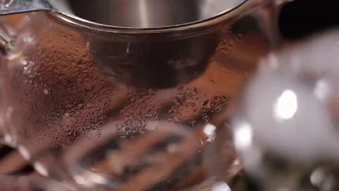 Process of pouring green tea oolong through strainer in glass chahai or bowl Video stock 100337030