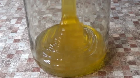 The process of pouring honey into a jar. Transfusion of yellow, sweet and Stock Footage 143164667