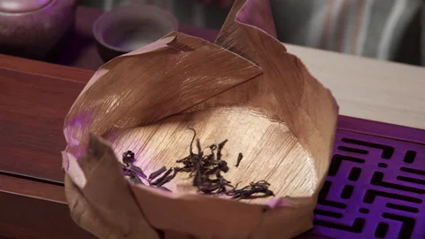 The process of pouring large-leaf tea into a special container for tea over a Stock Footage 145529618