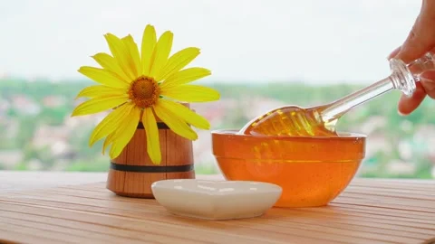 The process of pouring natural bee honey into a glass jar close up Stock Footage 241352766