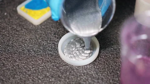Process of pouring silver colour epoxy resin from plastic cup into round Video stock 265892766