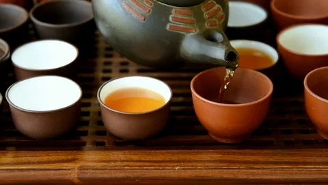 Process of pouring tea into cup from pot at ceremony. Chinese set on bamboo tray Stock Footage 93145645