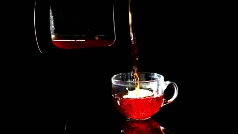 The process of pouring water from the kettle into the Cup on black background Stock Footage 229939987