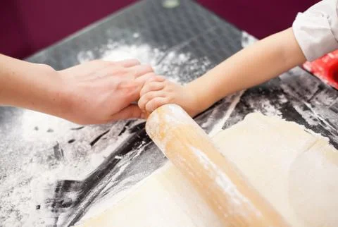 The process of preparation, rolling dough. Children's hands and the dough. In Stock Photos