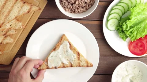 Process of prepare sandwich with sauce tuna cucumber lettuce tomato top view Stock-Footage 107932970