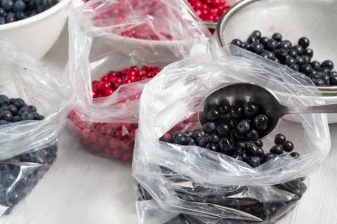 Process of preparing berries for freezing - folding into bags Stock Photos
