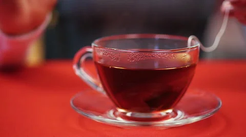 Process of preparing black tea. Woman pressing teabag with the help of spoon Stock Footage 62357014