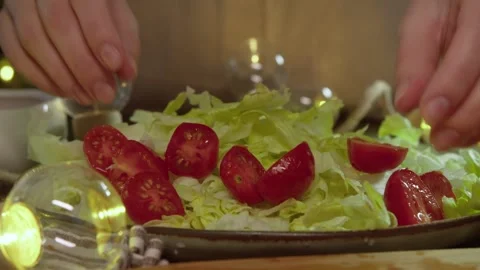 The process of preparing Caesar salad, which includes ripe cherry tomatoes and Stock Footage 300792653