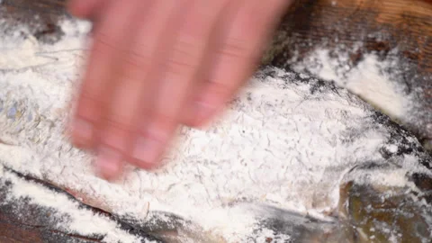 The process of preparing carp for frying in a frying pan, sprinkled with flour Stock Footage 251877523
