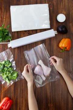 The process of preparing chicken legs for vacuum packaging and sealing Foto stock