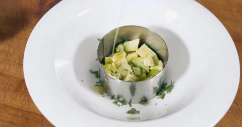 The process of preparing a delicious salad with avocado and olive oil on a white Stock Footage 152654913