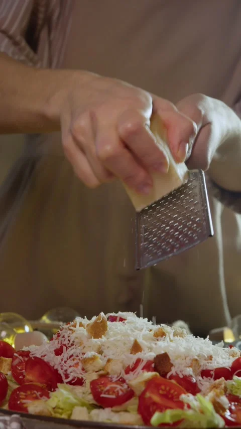 In the process of preparing a delicious vegetable salad, Gouda cheese is grated Stock Footage 300811544