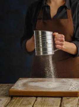 The process of preparing dough with the chef's hands on a dark background. Th Stock Photos
