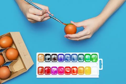 The process of preparing for Easter, the child paints Easter eggs with a brush Stock Photos