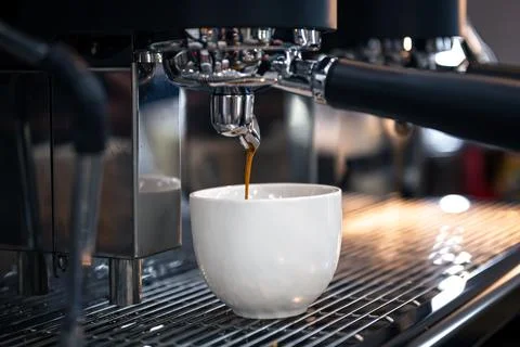 The process of preparing espresso in a professional coffee machine, close-up. Stock Photos