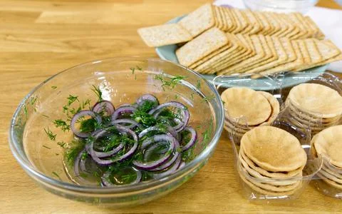 The process of preparing a festive snack on toast with sprats, onions, eggs and Stock Photos