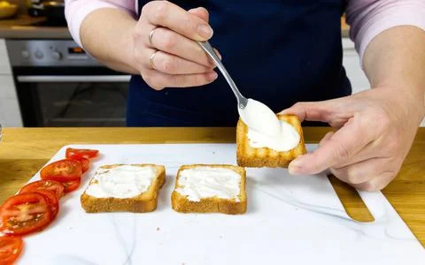 The process of preparing a festive snack on toast with sprats, onions, eggs and Foto stock