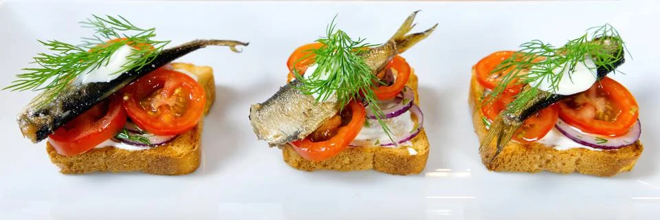 The process of preparing a festive snack on toast with sprats, onions, eggs and Stock Photos