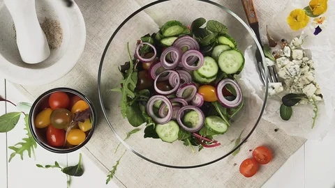 Process of preparing fresh vegetable salad with olive oil, top view. Video stock 125532661