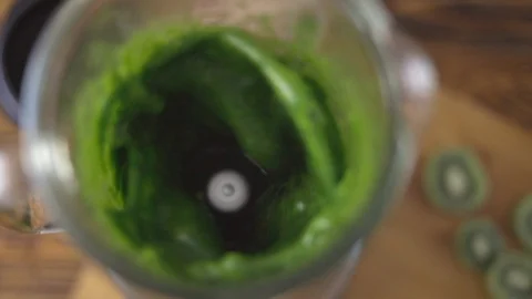 The process of preparing green smoothie in a kitchen, top view on blender. Stock Footage 101276754