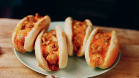 Process of preparing Irresistible chili cheese Hot Dogs. Taste USA cuisine witch Stock Footage 231549202