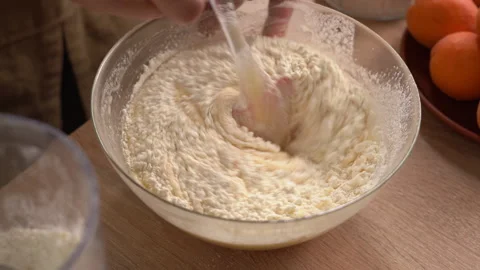 The process of preparing a liquid dough from eggs and flour, women's hands .. Stock Footage 341334283