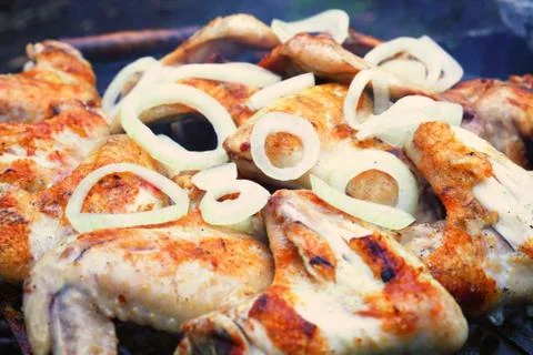 Process of preparing marinated chicken wings on the grill, chopped onion ring Foto stock