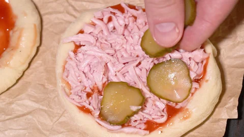 Process of preparing mini pizza, adding pickled cucumber Stock Footage 249881108