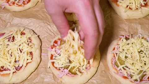 The process of preparing a mini pizza, adding grated cheese Vídeos de archivo 249882718