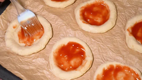 Process of preparing mini pizza, coated with tomato paste 動画素材 249880974