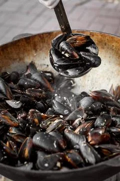 The process of preparing mussels in a large saucepan. Street food with seafoo Stock Photos