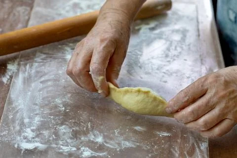Process of preparing pelmeni on floured surface. Close-up of an elderly wom.. Stock Photos