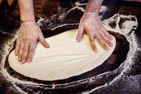 Process of preparing pizza dough, chef is wearing gloves. Stock Photos