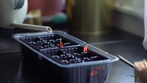 The process of preparing for planting seeds in a black plastic container. Woman Stock Footage 129576711