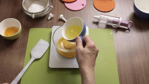 Process of preparing scales and utensils for making dough. Woman weighs egg Stock Photos