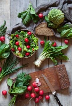 The process of preparing spring delicious salad with cucumber, radishes, spinach Stock Photos