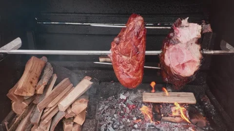 Process of preparing street food: Prague ham is roasted on rotisserie spit in Stock Footage 336120293